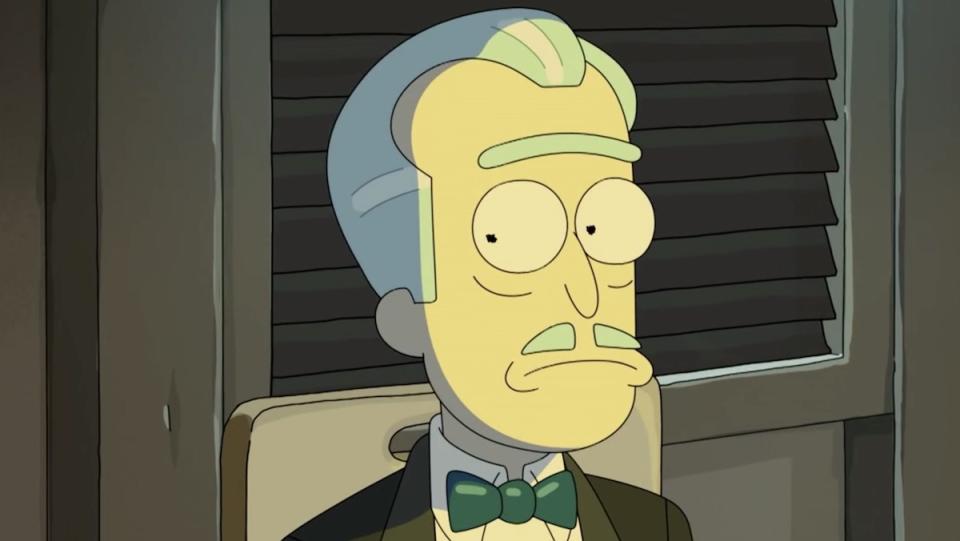 A short version of Rick, with slicked back hair, a mustache, and tuxedo with a green bow tie