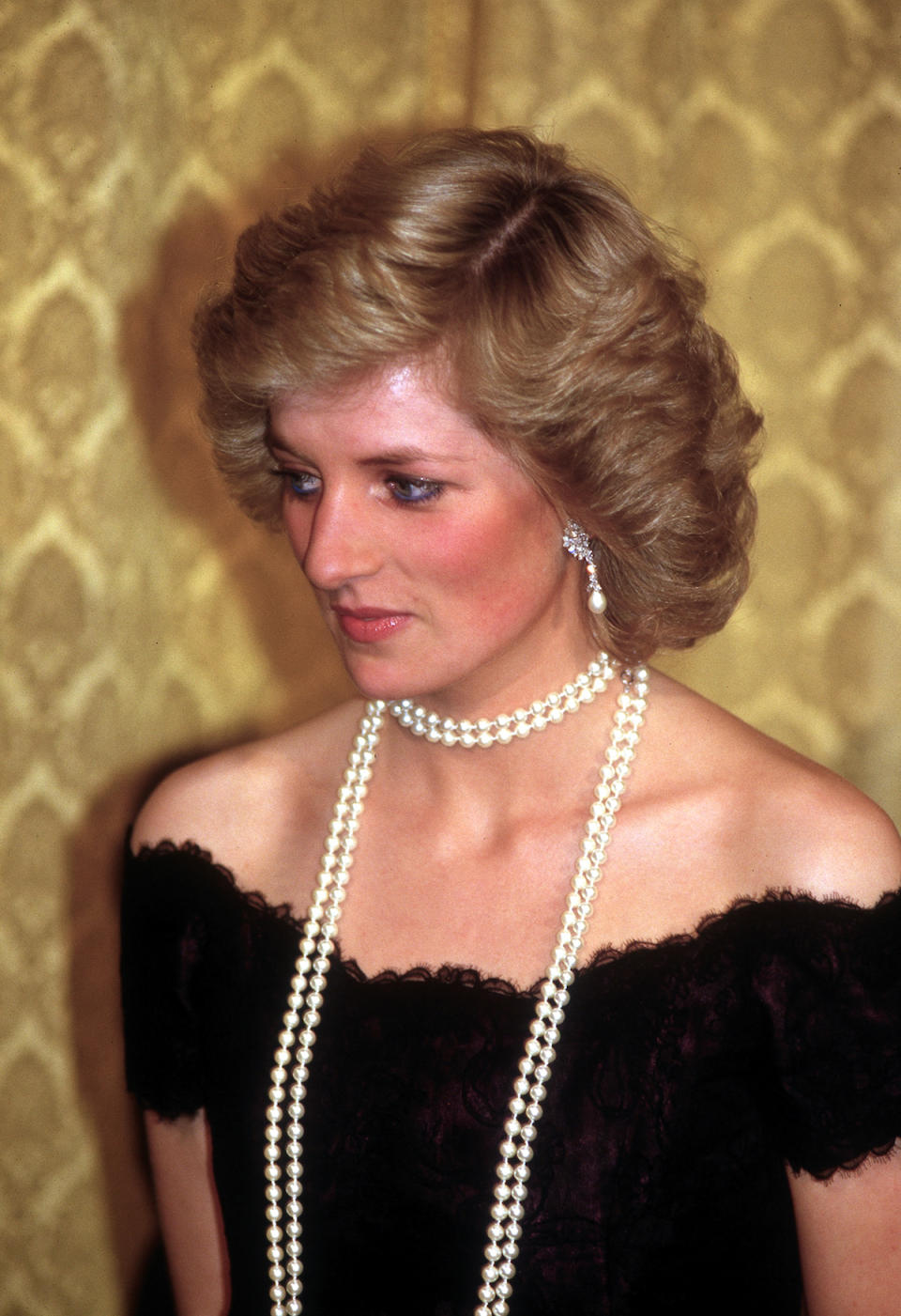 <p>Diana didn’t save the long strands of pearls for movie premieres but wore another string while attending a dinner in Hamburg, Germany, in November 1987. (Photo: Jayne Fincher/Getty Images) </p>