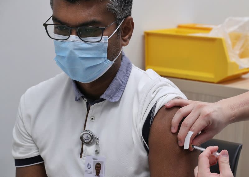 A healthcare worker receives a dose of the coronavirus disease (COVID-19) vaccine at the National Centre for Infectious Diseases (NCID) in Singapore