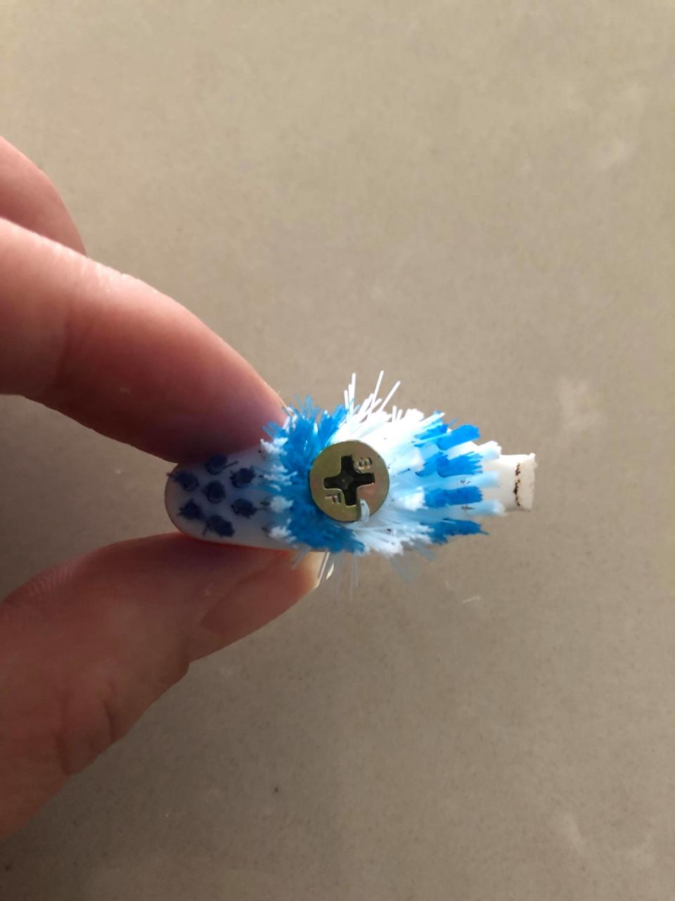 A toothbrush head with a screw screwed into it.