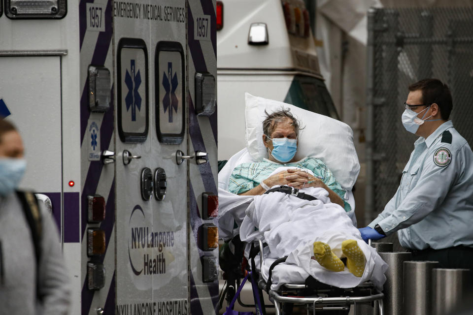 Patients and medical workers wear personal protective equipment due to COVID-19 concerns outside the emergency room at NYU Langone Medical Center, Monday, April 13, 2020, in New York. The new coronavirus causes mild or moderate symptoms for most people, but for some, especially older adults and people with existing health problems, it can cause more severe illness or death. (AP Photo/John Minchillo)