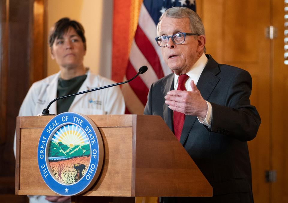 Gov. Mike DeWine speaks during a press conference as Dr. Sara Bode of Nationwide Children's Hospital stands behind him after he vetoed legislation that would have blocked cities like Columbus from banning the sale of menthol cigarettes and flavored vapes.