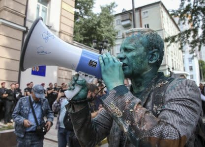 Head of the non-governmental Anti-Corruption Action Centre Vitaliy Shabunin, who was splashed with brilliant green substance, uses a loud-speaker during a rally in front of the Specialized Anti-Corruption Prosecutor's Office in Kiev, Ukraine July 17, 2018. REUTERS/Viacheslav Ratynskyi