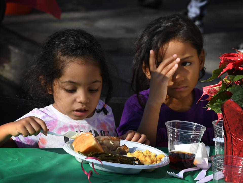 Children are among the desperately poor homeless who live on Los Angeles' Skid Row, which have been hurt by the teachers' strike. Here are two enjoying a meal last month at a holiday feast event.