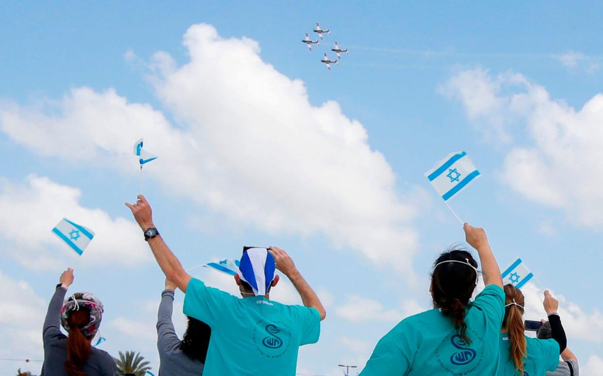 Israeli medical team of Sheba Medical Center at Tel HaShomer wave national flags as the Israeli Air Force - JACK GUEZ/AFP