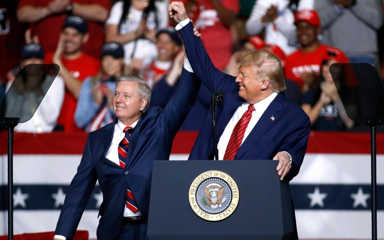 Sen. Lindsey Graham stands onstage with President Donald Trump during a Feb. 28 campaign rally in North Charleston, South Carolina - AP