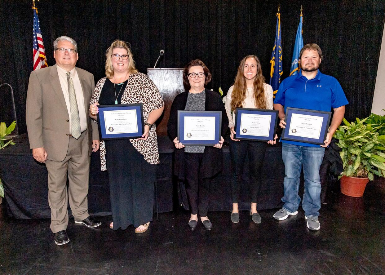 Among the Staff Senate award winners were Kelly Hawthorne, Sheri Hundley, Rachel Toews, and Shawn Ridenour, as president Thomas Newsom offers congratulations.