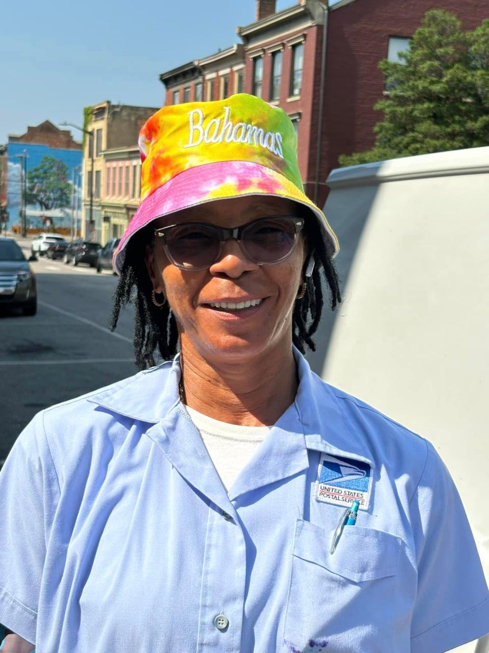 Pamela Taylor of Petersburg strikes a pose while on her mail route during a heat wave on July 16, 2024.