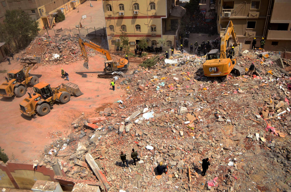 Rescuers sift through the rubble of a collapsed apartment building in the el-Salam neighborhood, in Cairo, Egypt Saturday, March 27, 2021. A nine-story apartment building collapsed in the Egyptian capital early Saturday, killing at several and injuring about two dozen others, an official said. (AP Photo/Tarek wajeh)