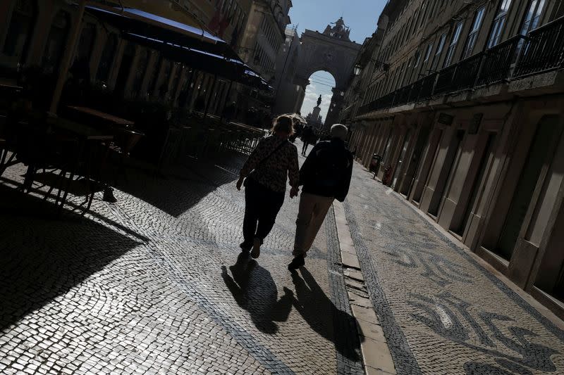 People walk down a street in downtown Lisbon