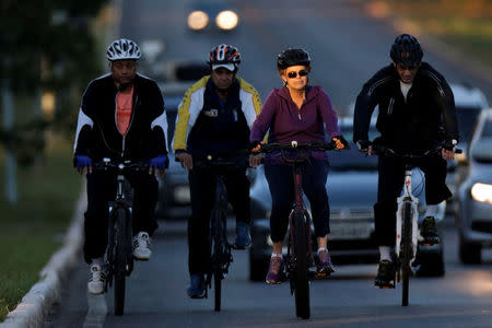 Brazil's President Dilma Rousseff rides her bicycle accompanied by bodyguards near the Alvorada Palace in Brasilia, Brazil April 15, 2016. REUTERS/Ueslei Marcelino