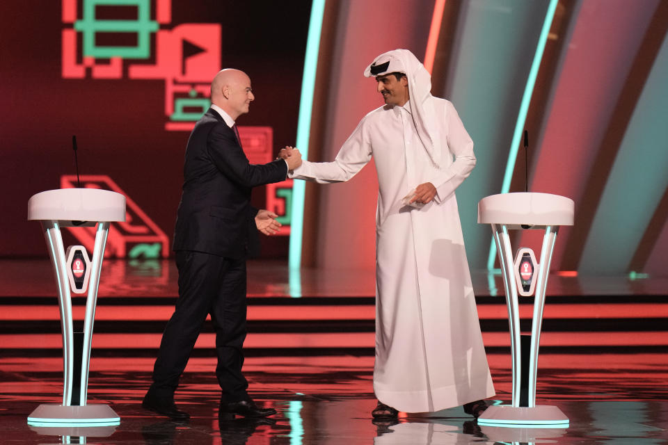 FILE - FIFA President Gianni Infantino, left, and Emir of Qatar Sheikh Tamim bin Hamad Al Thani shake hands before the 2022 soccer World Cup draw at the Doha Exhibition and Convention Center in Doha, Qatar, Friday, April 1, 2022. The first World Cup in the Middle East is only one month away. Qatar has been on an often bumpy 12-year journey that has transformed the nation. (AP Photo/Hassan Ammar, File)