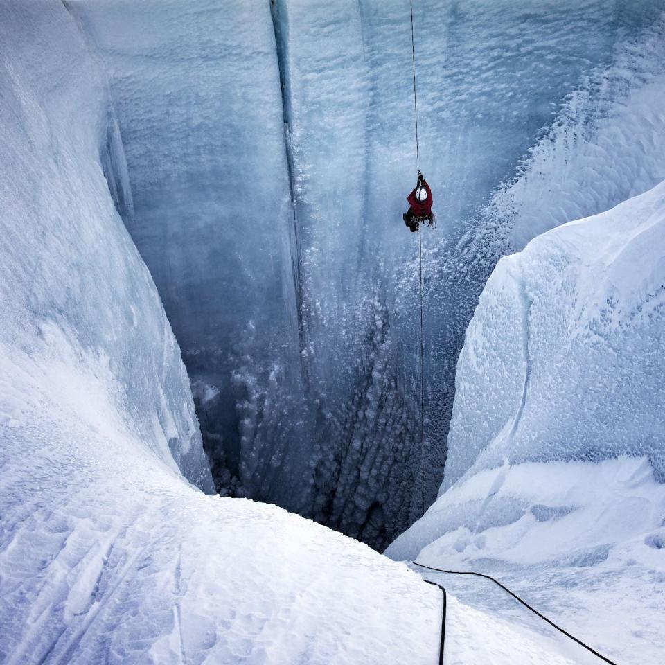 Alun Hubbard rappels into a moulin in October 2019, a point in the year when surface melt should have ceased but hadn’t. Lars Ostenfeld / Into the Ice