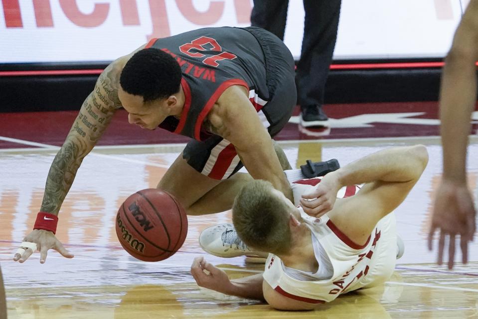 Ohio State's CJ Walker and Wisconsin's Brad Davison go after a loose ball during the second half of an NCAA college basketball game Saturday, Jan. 23, 2021, in Madison, Wis. (AP Photo/Morry Gash)