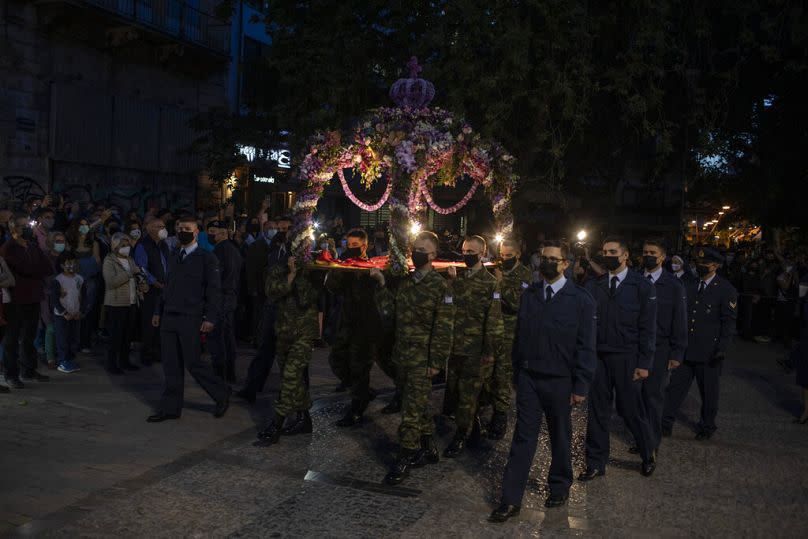 Soldados griegos llevan el Epitaphios durante una procesión del Viernes Santo frente a la catedral ortodoxa de Atenas, el viernes 30 de abril de 2021.