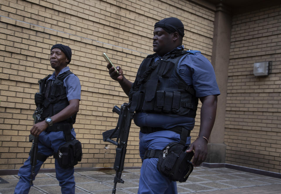 Armed police patrol outside the High Court in Pretoria, South Africa, Monday March 25, 2024. South African prosecutors say they intend to charge the Parliament speaker with corruption. They allege she took $135,000 and a wig in bribes from an unnamed person over a three-year period while she was defense minister. (AP Photo/Denis Farrell)