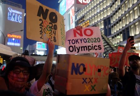 People protest against the Tokyo 2020 Olympics on the day marking one year out from the start of the summer games, at Shinjuku district in Tokyo