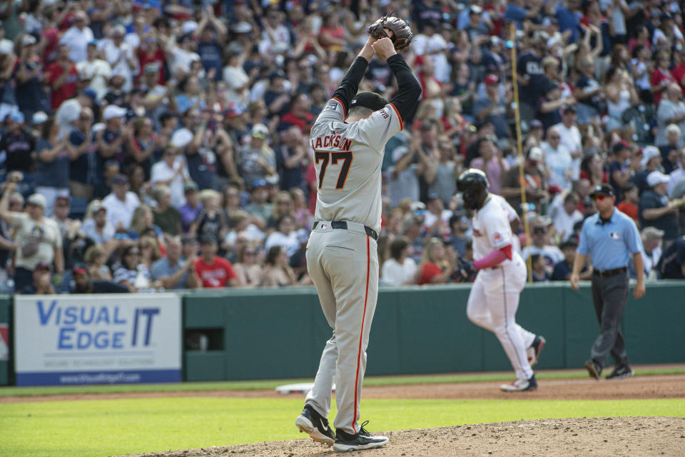 San Francisco Giants relief pitcher Luke Jackson (77) reacts as Cleveland Guardians' Jhonkensy Noel, rear, rounds the bases after hitting a solo home run during the fifth inning of a baseball game in Cleveland, Saturday, July 6, 2024. (AP Photo/Phil Long)