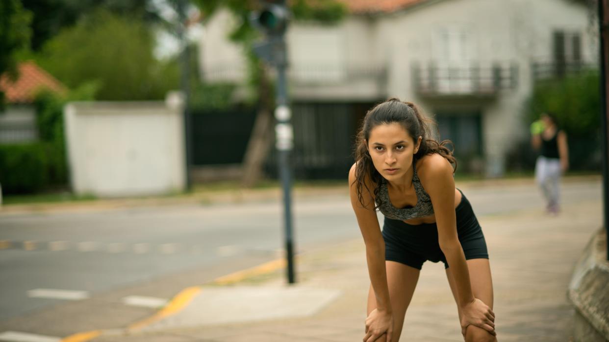  Tired woman resting after running. 