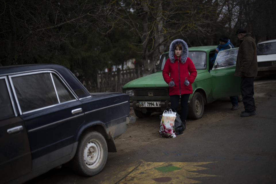 A woman waits for aid workers in Kalynivske, a village that was hit by shelling last fall in Ukraine, Saturday, Jan. 28, 2023. (AP Photo/Daniel Cole)