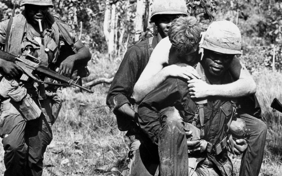 A wounded soldier carried by members of the 1st Calvary Division, about two miles from the Cambodian border - Bettmann