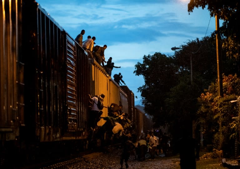 Undocumented migrants climb on a train known as "La Bestia" (The Beast), in the town of Las Patronas in Mexico's Veracruz state hoping to reach the US