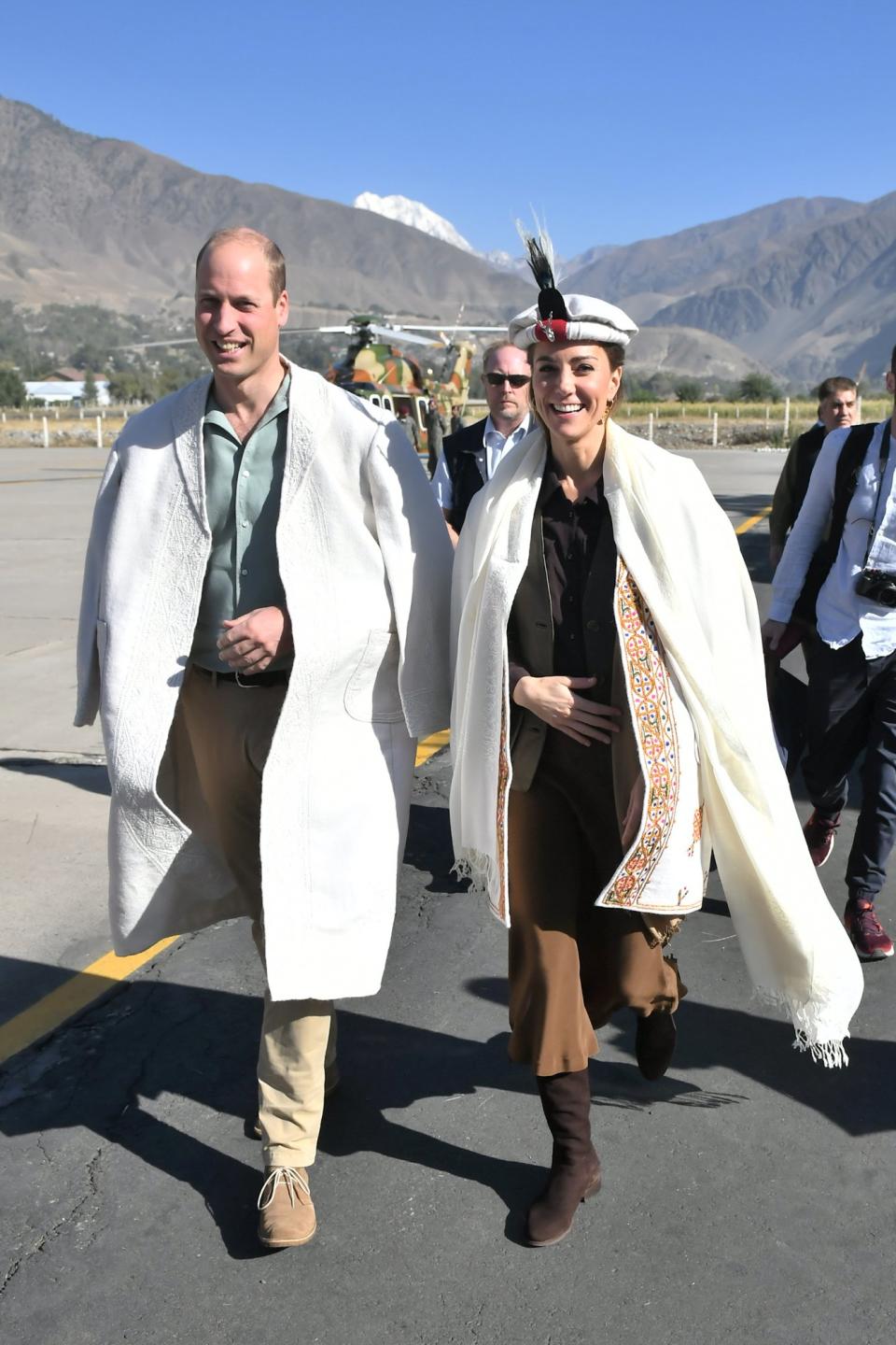The royals headed to the mountains on Wednesday, part of their desire to see the effect that climate change and global warming are having on the local communities in the northern region of the country. Upon arrival, the royals were presented with traditional Chitrali hats as they landed in Chitral the Hindu Khush, near the Afghan border. Kate sported her traditional hat with a warm shawl and colorful embroidered jacket she was also given, which she placed over her leather vest, brown shirt tucked into a belted skirt and flat boots. William, who was given a long white embossed coat, placed his new accessory over his green button-down and slacks.