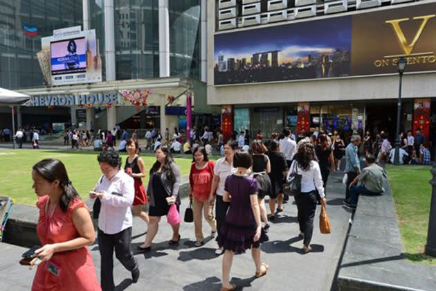 Pedestrians walk down a street in downtown financial district in Singapore on January 29, 2013. (AFP photo)