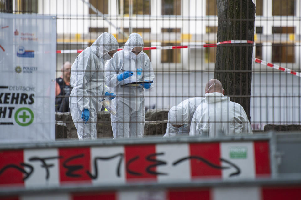 Forensics staff stand near the 'Protestant School Neukoelln' in Berlin, Germany, Wednesday, May 3, 2023. Berlin police say two young children were seriously wounded in an attack at a school in the south of the capital. Police said the victims were girls aged 7 and 8 years. One is in a life-threatening condition, they said in a statement. (Christophe Gateau/dpa via AP)