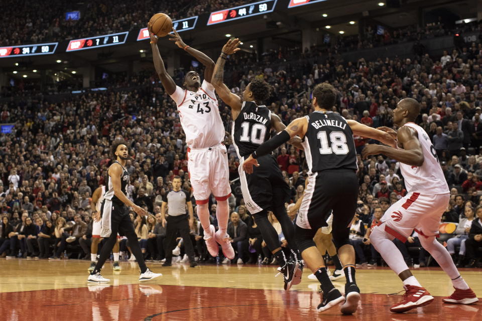 Toronto Raptors forward Pascal Siakam, center, shoots over San Antonio Spurs' DeMar DeRozan during second half NBA basketball action in Toronto on Sunday Jan. 12, 2020. (Chris Young/The Canadian Press via AP)