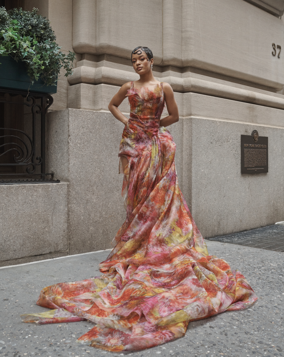 a woman wearing a floral dress in a hotel suite