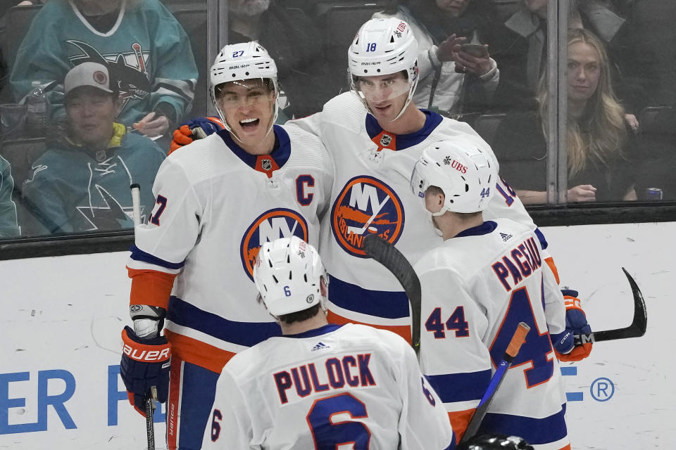 New York Islanders left wing Anders Lee, top left, is congratulated by left wing Pierre Engvall, top right, center Jean-Gabriel Pageau (44) and defenseman Ryan Pulock (6) after scoring against the San Jose Sharks during the third period of an NHL hockey game in San Jose, Calif., Thursday, March 7, 2024. (AP Photo/Jeff Chiu)