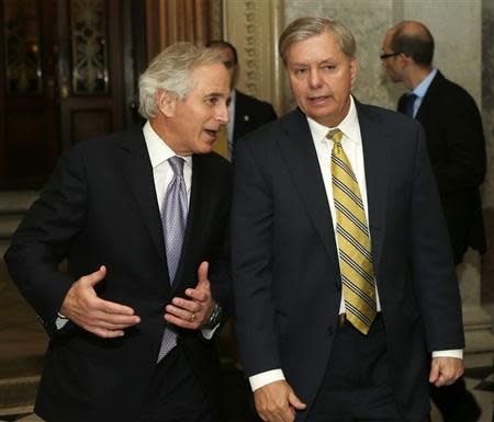 Senators Bob Corker (R-TN) (L) and Lindsey Graham (R-SC) walk out of the Senate chamber after voting on the U.S. budget bill in Washington December 18, 2013. REUTERS/Gary Cameron