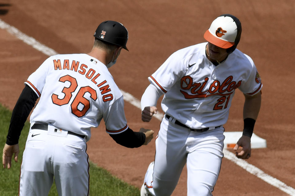 Baltimore Orioles' Austin Hays (21) celebrates with third base coach Tony Mansolino (36) after hitting a two-run home run against the Oakland Athletics in the fourth inning of a baseball game, Sunday, April 25, 2021, in Baltimore. (AP Photo/Will Newton)
