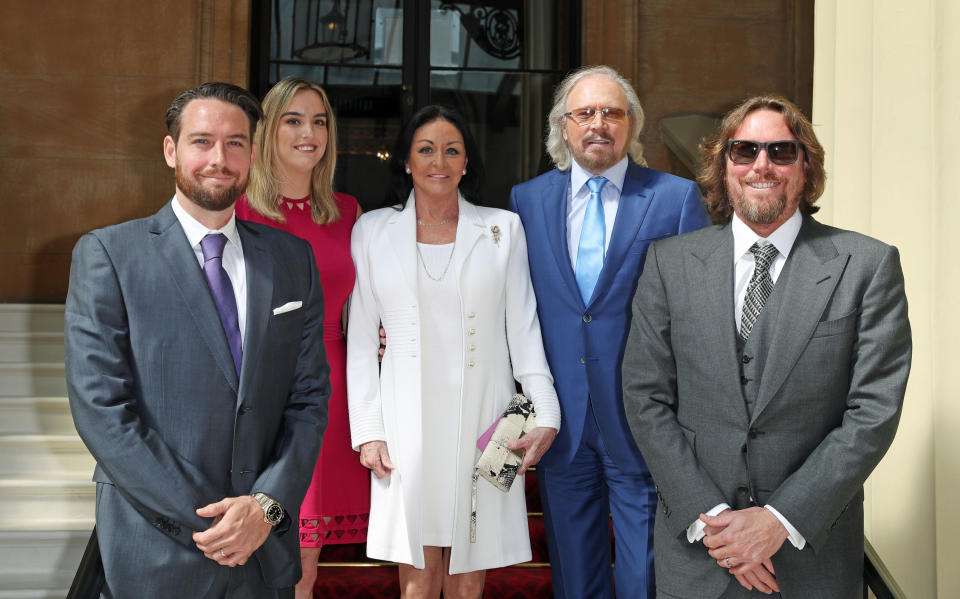 LONDON, ENGLAND - JUNE 26: Singer and songwriter Barry Gibb (2R) poses for a photo with his wife Linda, and children, Michael, Alexandra and Ashley ahead of being knighted during an investiture ceremony at Buckingham Palace on June 26, 2018 in London, England. (Photo by Steve Parsons - WPA Pool/Getty Images)