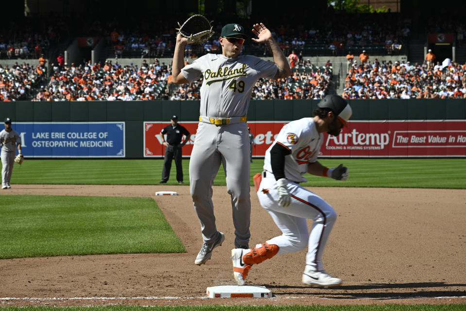 Baltimore Orioles' Ryan McKenna, right, is safe at first with a single against Oakland Athletics first baseman Ryan Noda (49) during the seventh inning of a baseball game, Sunday, April 28, 2024, in Baltimore. McKenna advanced to second on a throwing error by Athletics catcher Kyle McCann. (AP Photo/Nick Wass)