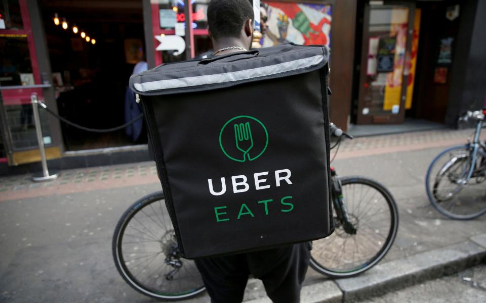 FILE PHOTO: An UberEATS food delivery courier stands in front of his bike in London, Britain September 7, 2016. Picture taken September 7, 2016. REUTERS/Neil Hall/File Photo - NEIL HALL/REUTERS