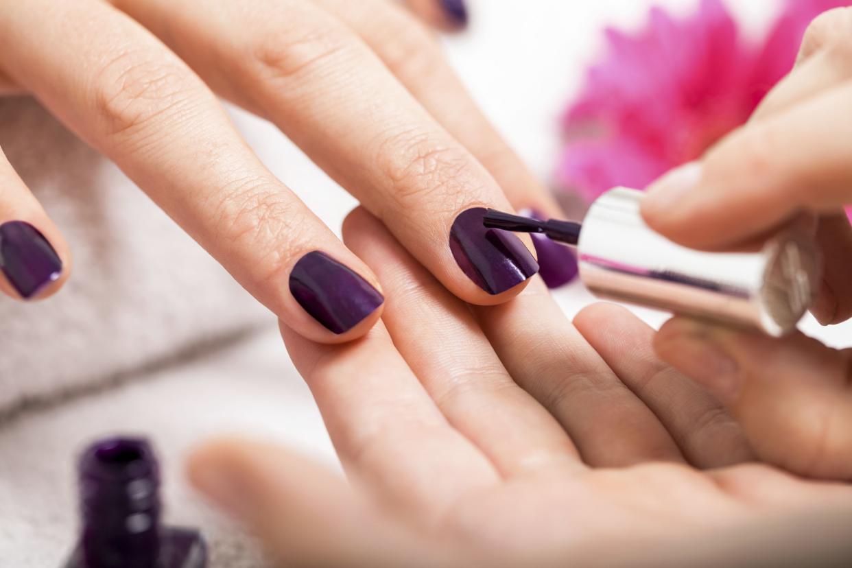 Woman having a nail manicure in  beauty salon
