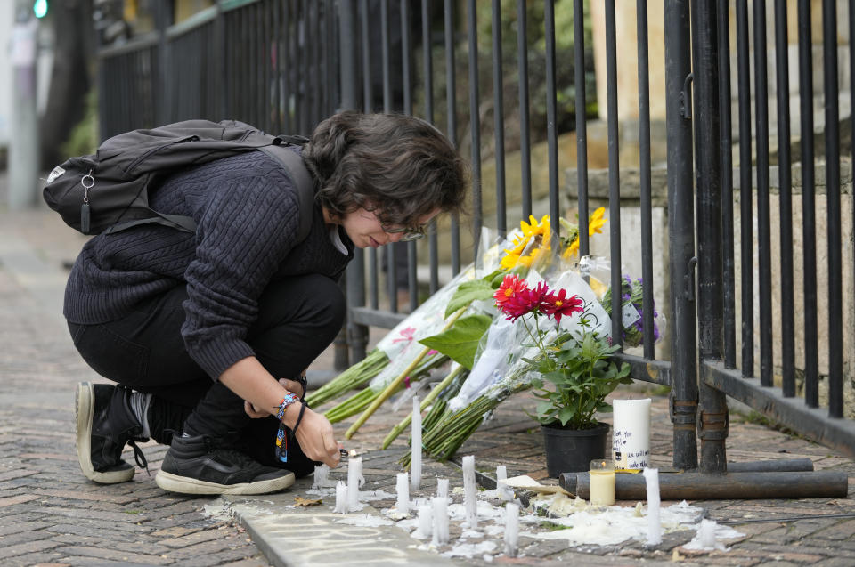 Una fan de los Foo Fighters coloca velas en una ofrenda fuera del hotel donde el baterista de la banda Taylor Hawkins fue encontrado muerto en el norte de Bogotá, Colombia, el sábado 26 de marzo de 2022. Los Foo Fighters han cancelado sus próximas fechas de conciertos tras la muerte de Hawkins. (Foto AP/Fernando Vergara)