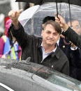 Brazil's President Jair Bolsonaro waves on his arrival at Kansai International Airport in Izumisano, Osaka prefecture, western Japan, Thursday, June 27, 2019. Group of 20 leaders gather in Osaka on June 28 and 29 for their annual summit.(Nobuki Ito/Kyodo News via AP)