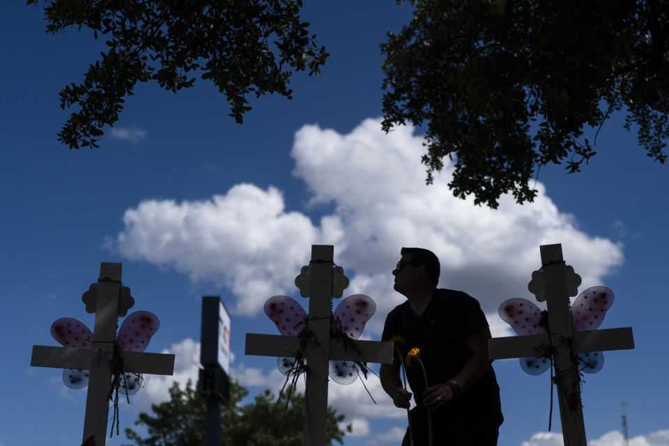 Matthew Solano leaves sunflowers at a memorial to honor the victims killed in last week's elementary school shooting in Uvalde, Texas, Wednesday, June 1, 2022. On May 24, 2022, an 18-year-old entered the school and fatally shot several children and teachers. (AP Photo/Jae C. Hong)