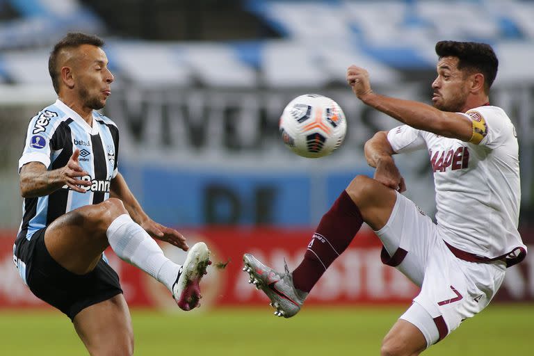 Rafinha of Brazil's Gremio, left, and Lautaro Acosta of Argentina's Lanus battle for the ball during a Copa Sudamericana soccer match in Porto Alegre, Brazil, Thursday, May 13, 2021. (Silvio Avila/Pool via AP)