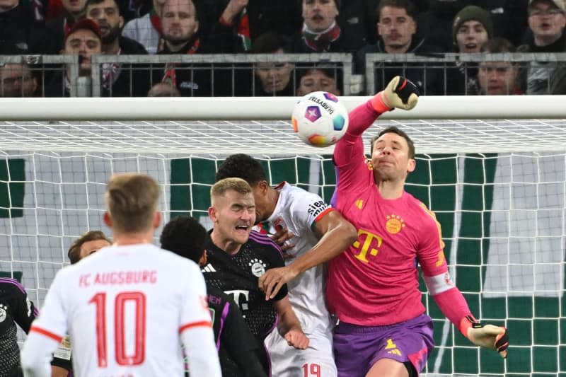 Bayern Munich goalkeeper Manuel Neuer (R) saves his nets during the German Bundesliga soccer match between FC Augsburg and Bayern Munich at the WWK-Arena. Sven Hoppe/dpa