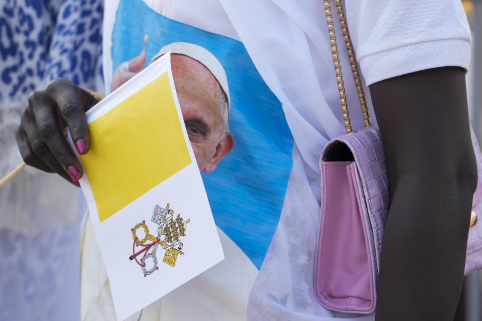 Una mujer sostiene una bandera del Vaticano mientras asiste a una misa celebrada por el papa Francisco el domingo 5 de febrero de 2023, en Juba, Sudán del Sur. (AP Foto/Gregorio Borgia)