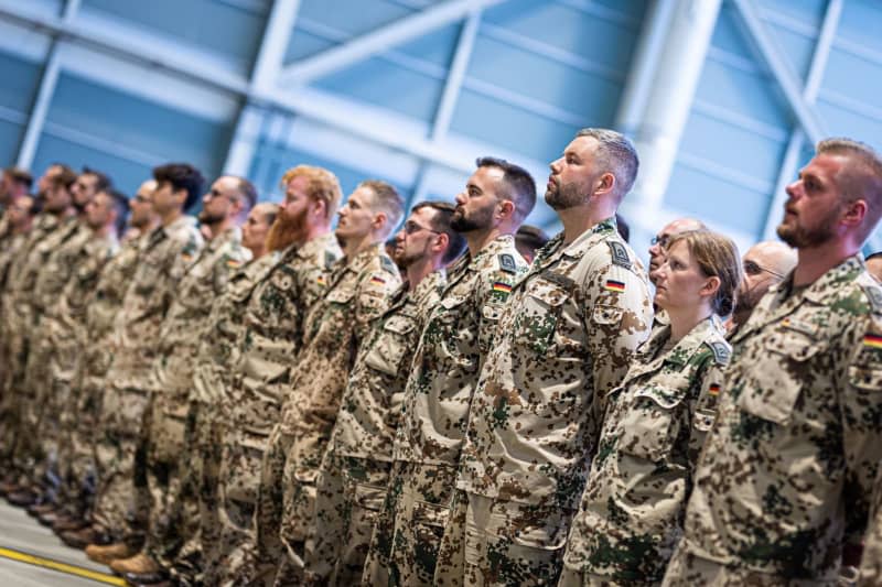 Bundeswehr soldiers stand in a hangar at Wunstorf air base in the Hanover region in the evening for a recall. The German armed forces have ended an eight-year deployment in Niger after handing over control of a key air base in the West African country. Moritz Frankenberg/dpa