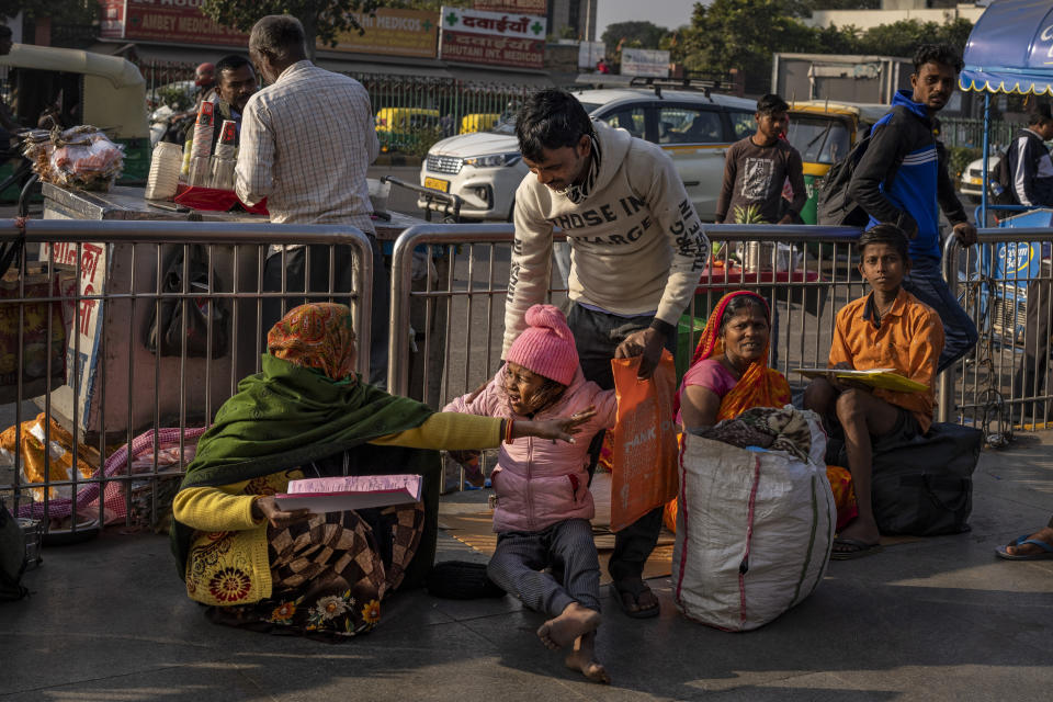 Savita Devi, left, tends to her sick daughter Srishtri Kumari, as they squat outside the All India Institute of Medical Sciences (AIIMS) hospital in New Delhi, India, Wednesday, Dec. 7, 2022. The leading medical institute in India's capital limped back to normality on Wednesday after a cyberattack crippled its operations for nearly two weeks. (AP Photo/Altaf Qadri)