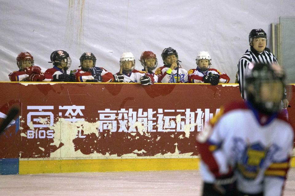 In this Saturday, Feb. 18, 2017, photo, Chinese players watch the action during a youth ice hockey tournament in Beijing. The NHL sees China as hockey’s next great frontier. With the 2022 Winter Olympics in Beijing, China is eager to step up its game and the league is intrigued by the potential of a new nontraditional market with 1.3 billion people that might take to hockey like it did basketball.(AP Photo/Mark Schiefelbein)