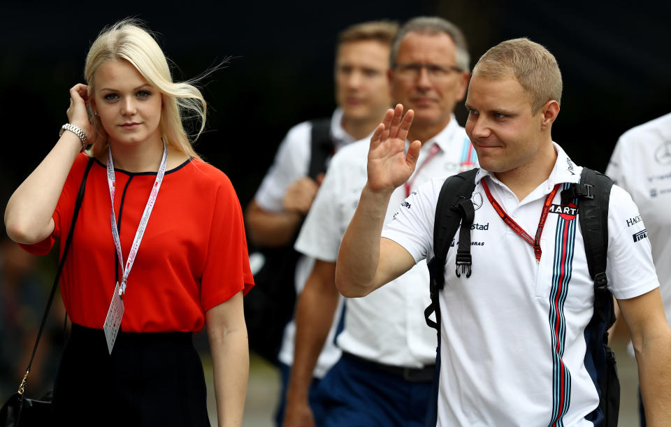 SINGAPORE - SEPTEMBER 17: Valtteri Bottas of Finland and Williams walks into the paddock with wife Emilia Pikkarainen before final practice for the Formula One Grand Prix of Singapore at Marina Bay Street Circuit on September 17, 2016 in Singapore.  (Photo by Lars Baron/Getty Images)