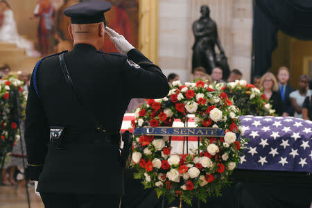 Capitol Police Honor Guard salutes the casket of Senator McCain who lies in state in the Rotunda at the U.S. Capitol in Washington, U.S., August 31, 2018. REUTERS/Mary F. Calvert