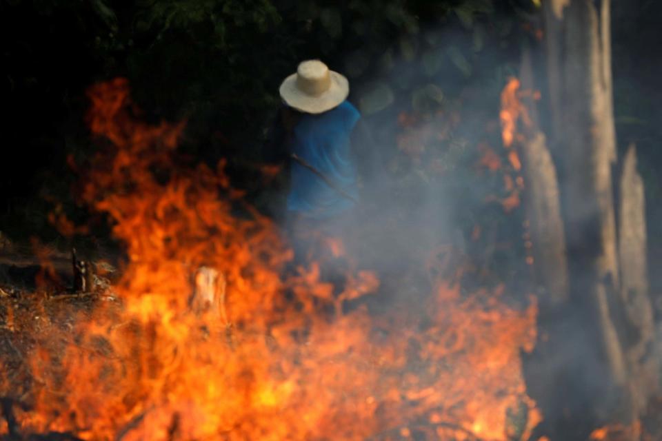 A man works in a burning tract of Amazon jungle as it is being cleared by loggers and farmers in Iranduba, Amazonas state. (REUTERS)